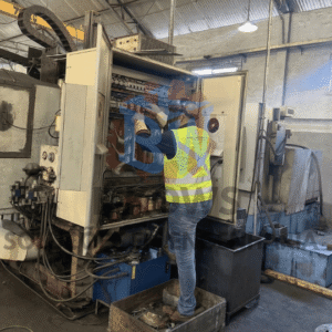 Home 11 Técnico realizando intervenção em painel elétrico de máquina industrial durante execução de projeto de engenharia